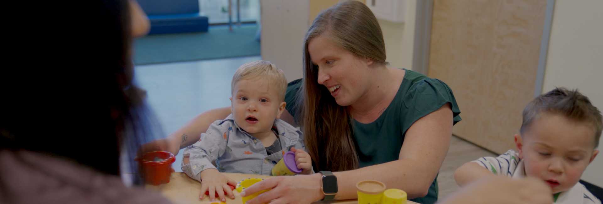 a teacher plays toys with two children