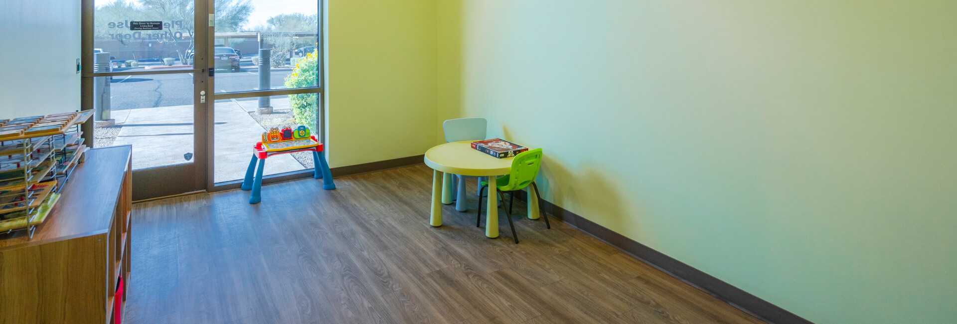 a room inside the Scottsdale Children's Institute with a bookshelf and table in the corner