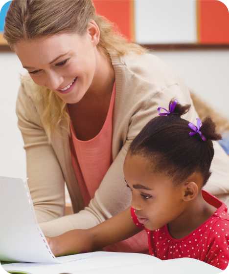 a woman and a child sit with an open book and piece of paper