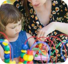 a child and a woman play with an interactive toy