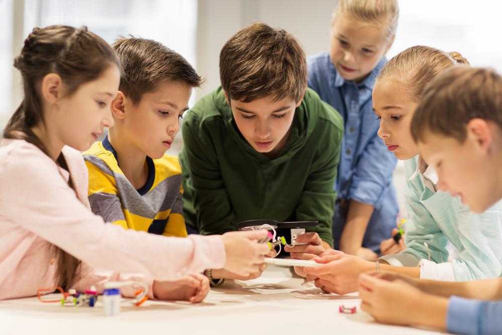 children work together on robots piece together