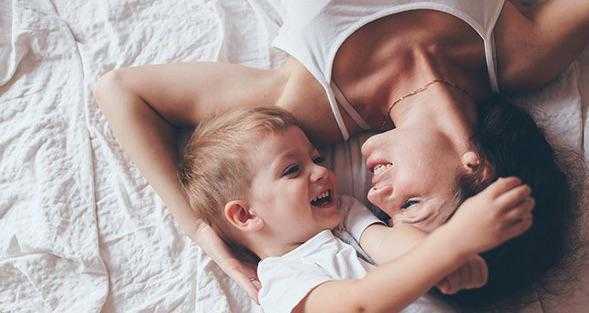 a woman and young boy embrace and smile