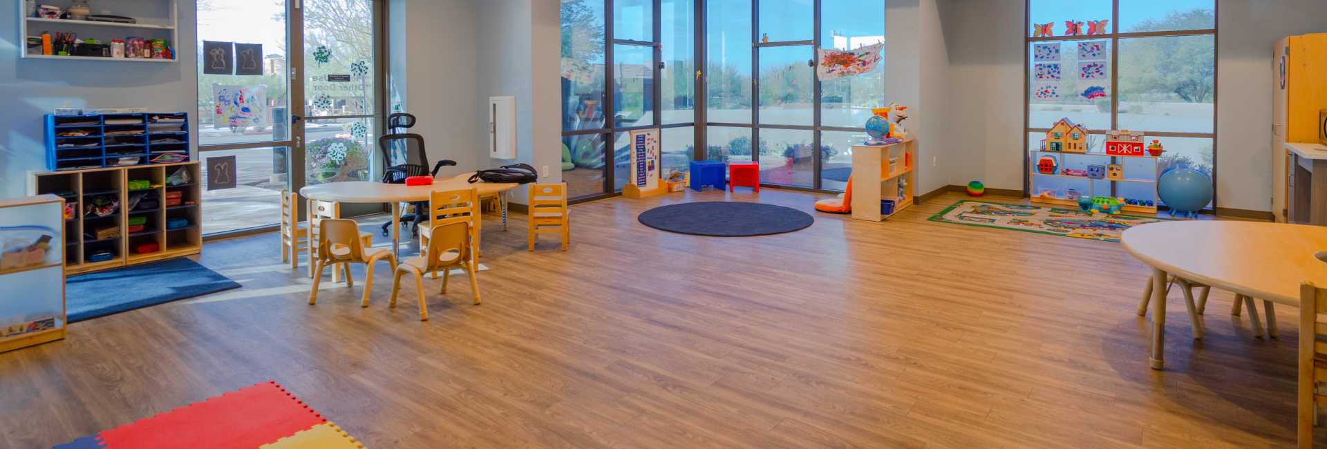 a wideshot of the playroom in the Scottsdale Children's Institute featuring tables, chairs, and toys