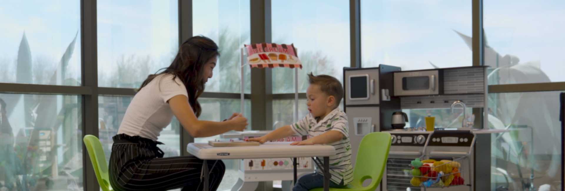 a woman and a child at a desk learning