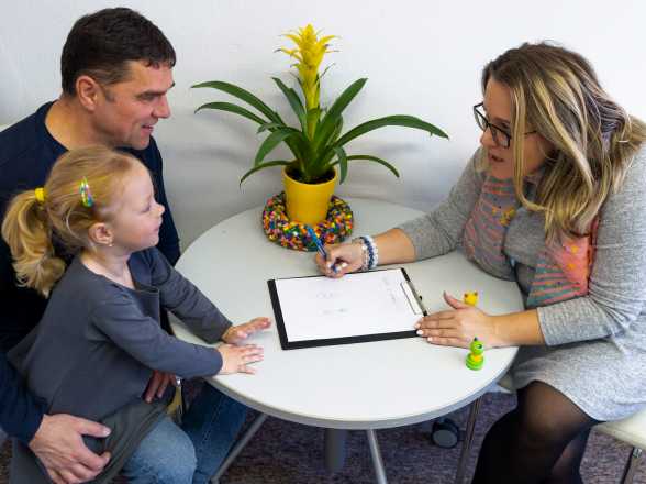 a woman asks a little girl and her father questions