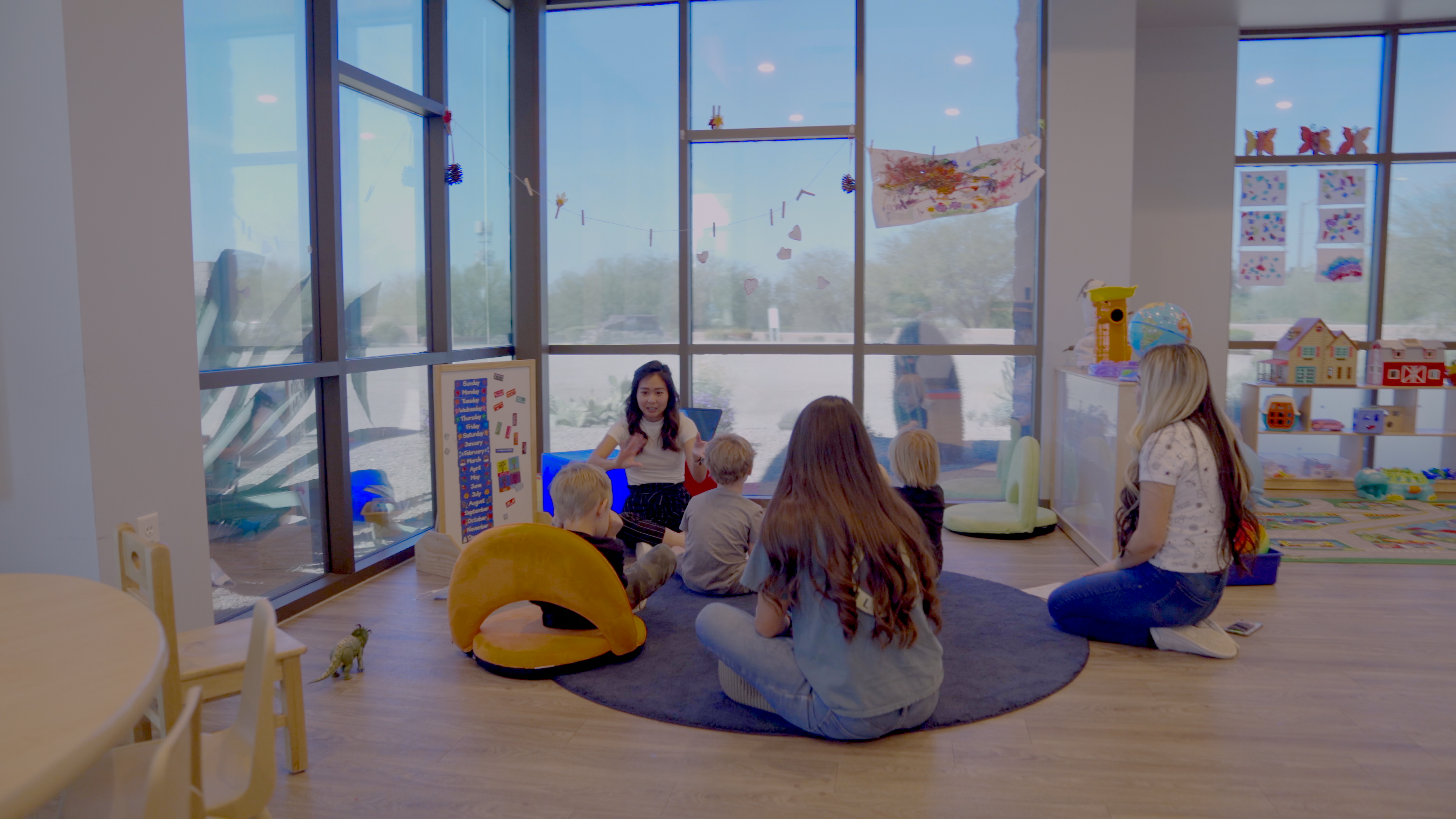 Children on floor surrounded by teachers